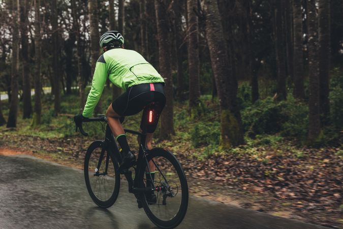 Male cyclist training on wet road