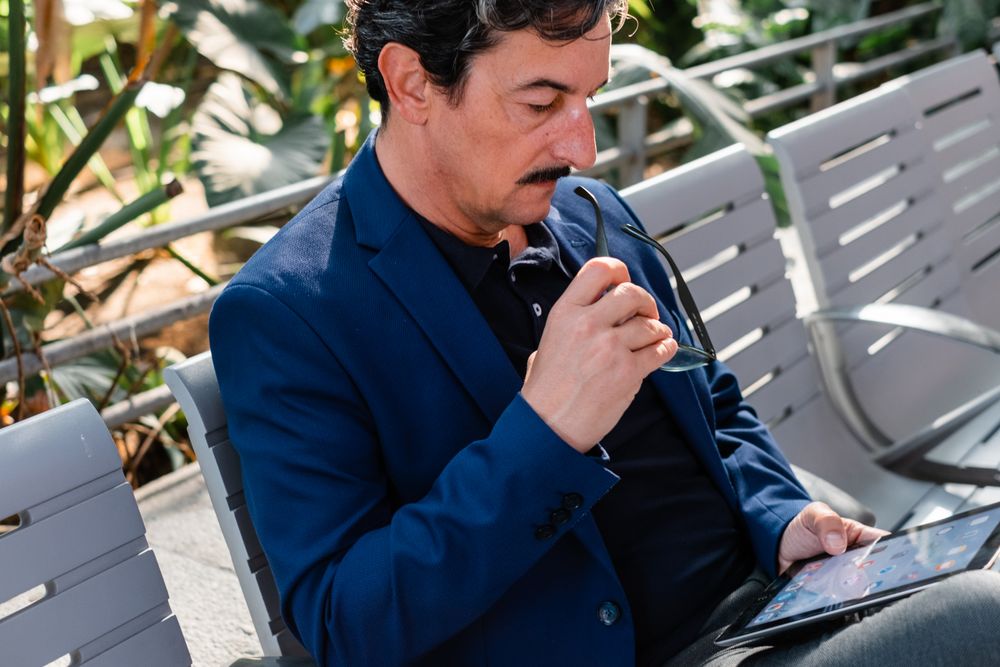 Older handsome man using digital tablet outdoors