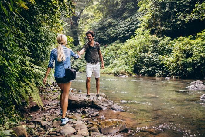 Couple on hikers in forest by the stream
