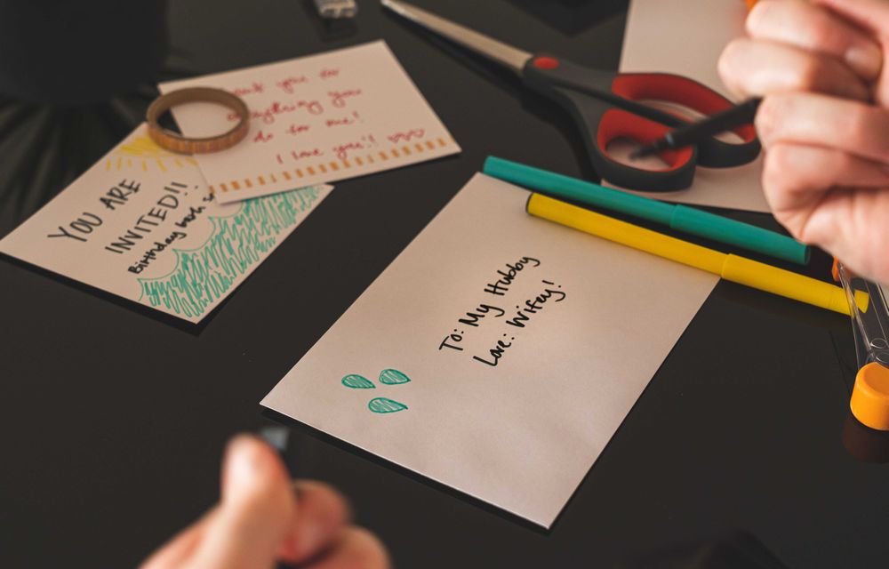 Cropped image of a hand holding a pen beside an envelope