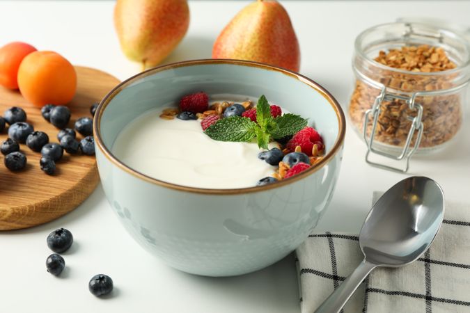 Composition with yogurt dessert and ingredients on plain background, space for text