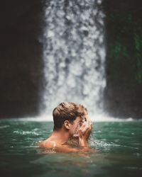 Man swimming in turquoise natural bay