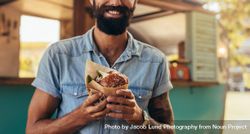 Man with beard having street food bxyVM0