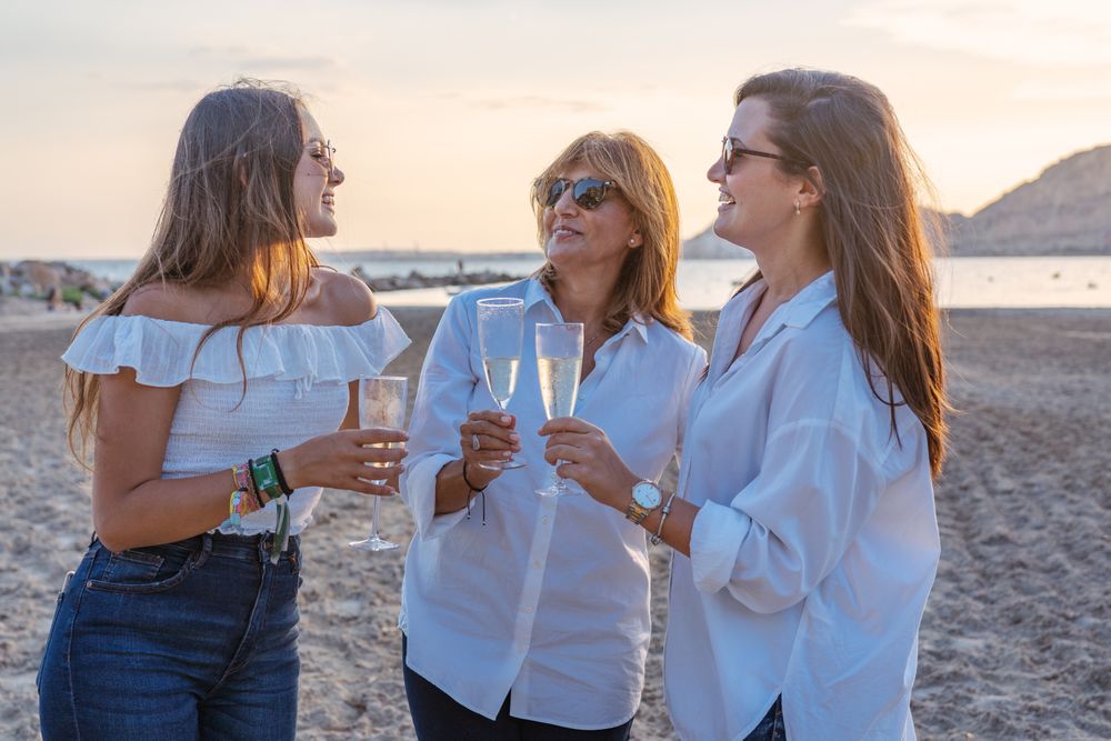 Happy family drinking wine on beach