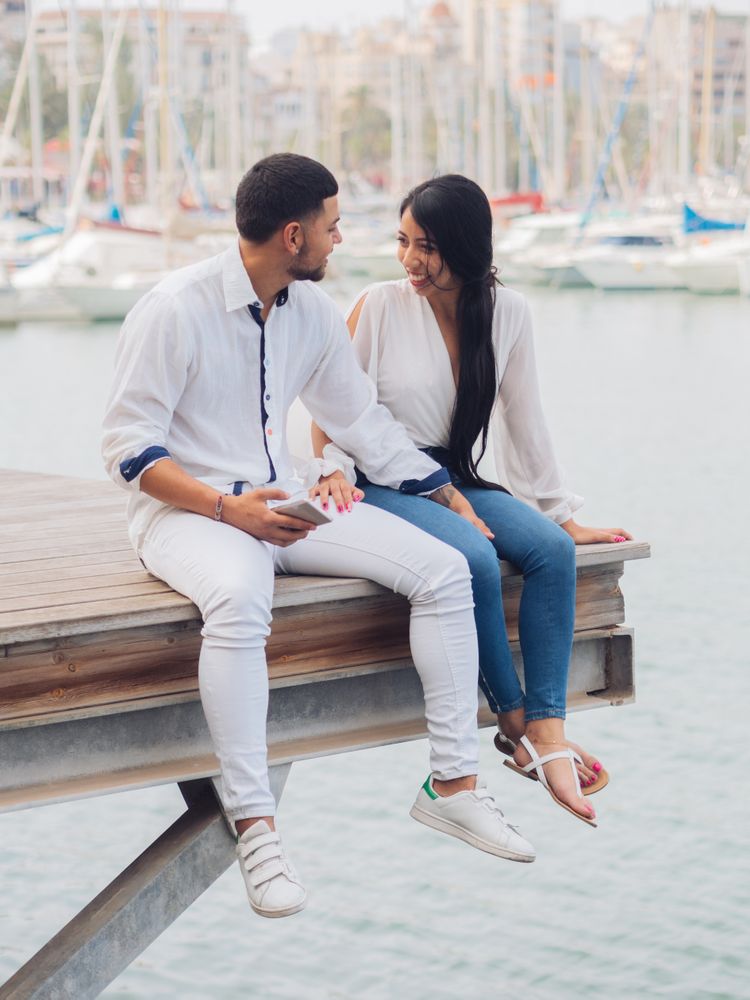 Man and woman sitting on dock with feet
