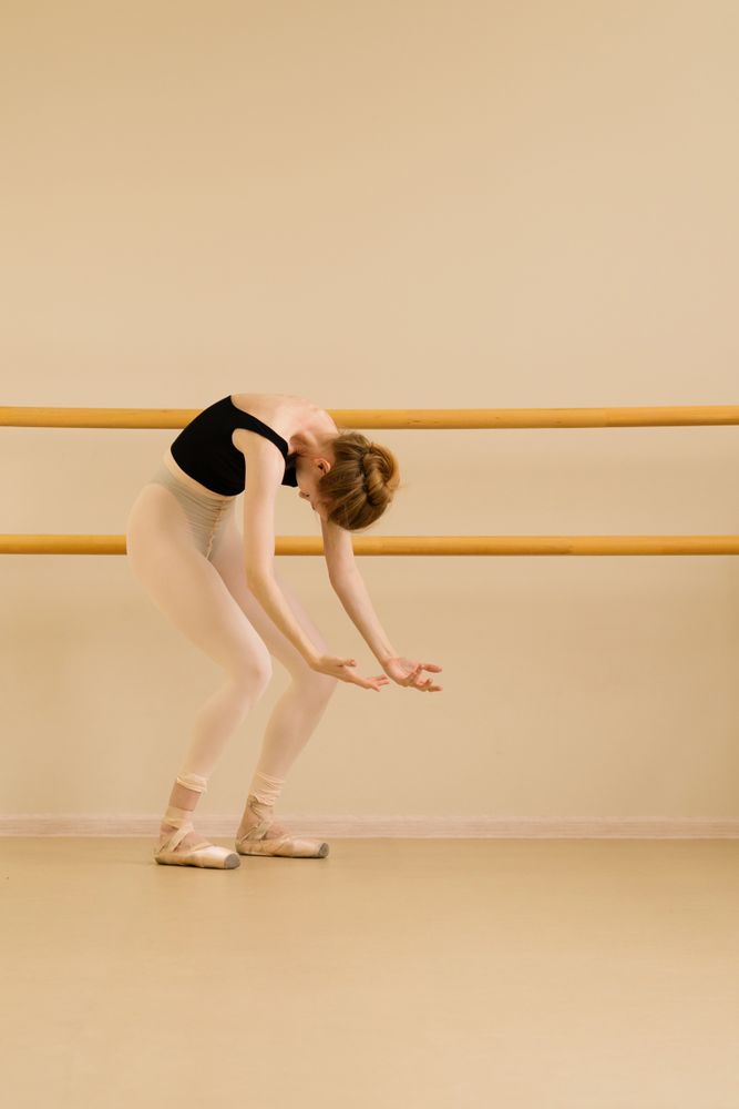 Ballet dancer extending arms in graceful arc.
