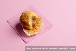 Muffin partially eaten on pink background 5RMkr0