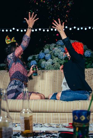 Happy women throwing confetti in the air at a party