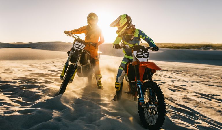 Two motocross bike riders on desert track