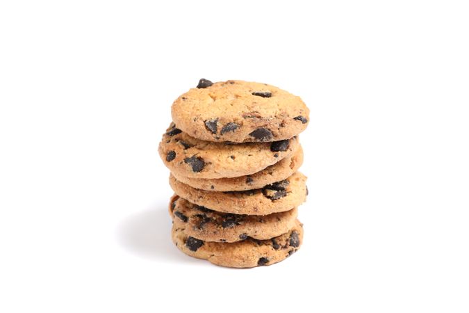 Stack of tasty chocolate chip cookies on plain background