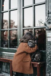 Girl hugging sad dog on city street