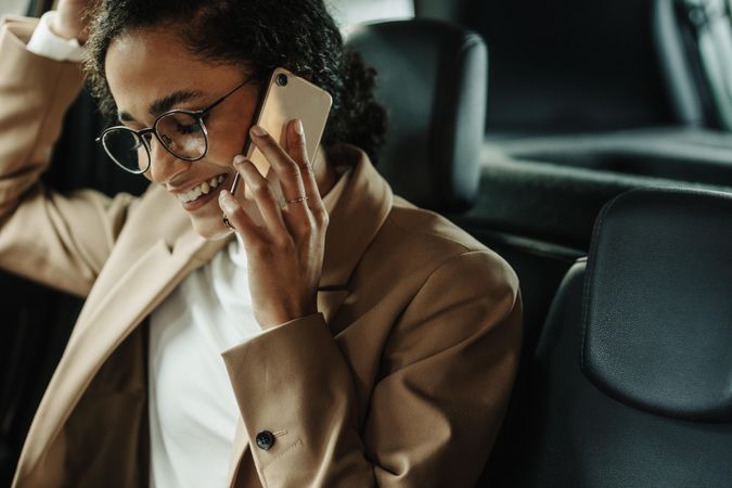Businesswoman sitting in her car and talking on phone
