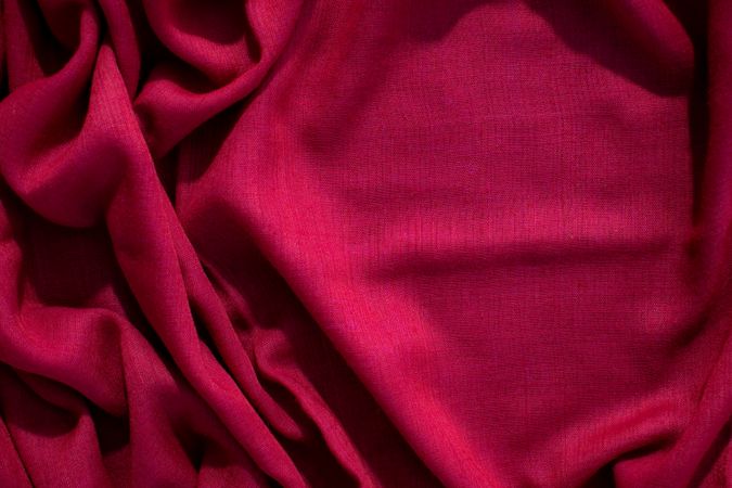 Red fabric wavy crumpled background texture with copy space.