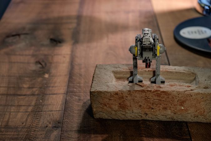 Lego robot figure on brick on desk
