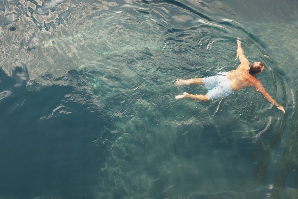 Man swimming in blue water