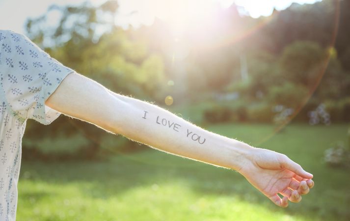 Male arm with text -I love you- written on skin
