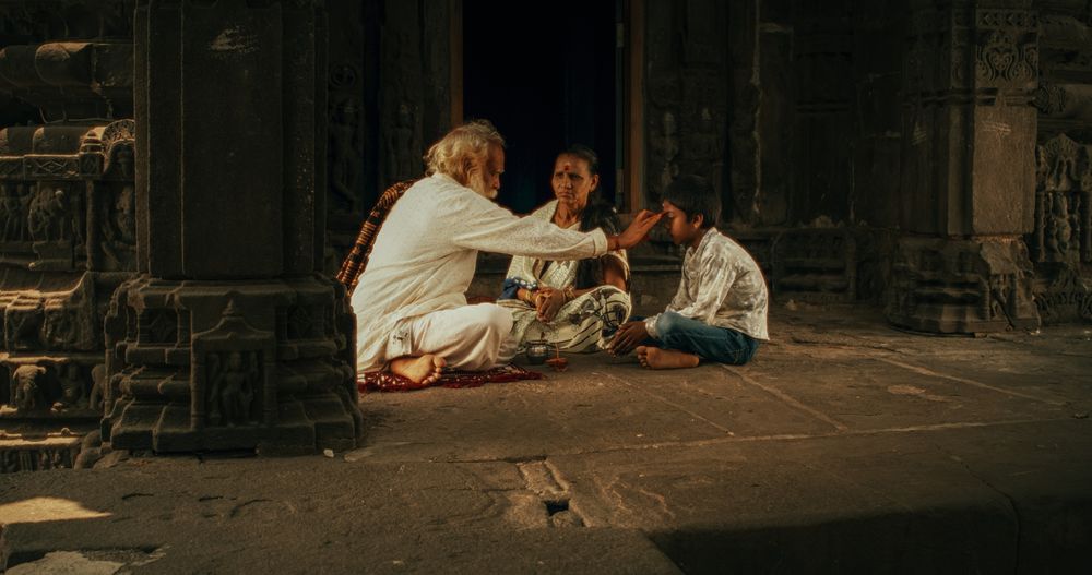 Authentic Footage of Hindu Priest Tying a Mauli Thread Around a Female Temple Follower's Wrist.