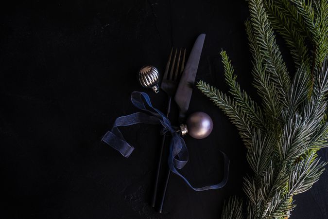 Minimal Christmas table setting with cutlery and silver ornaments