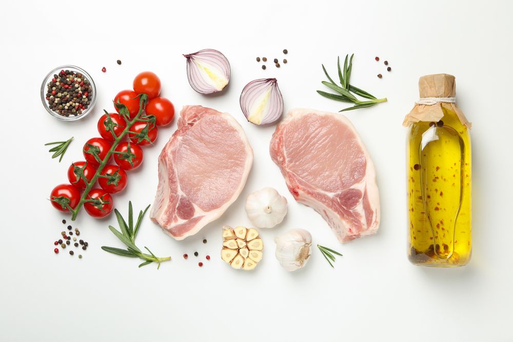 Composition with raw meat and ingredients on light background, top view