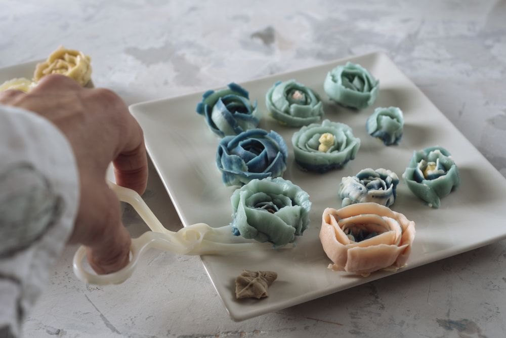 Hand holding buttercream flower