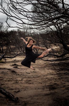 Woman dancing between dry trees