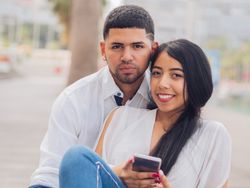 Man bonging smiling woman having fun with smartphone