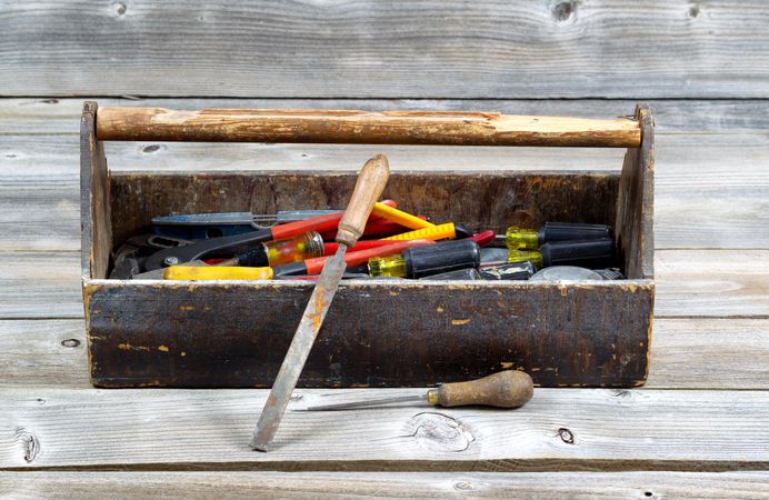 Old wooden toolbox filled with work tools