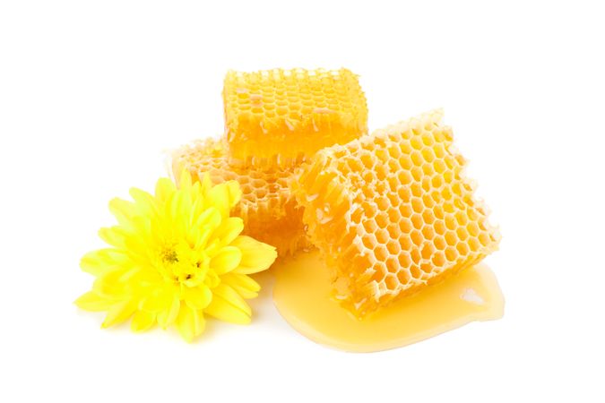 Pieces of honeycomb and chrysanthemum isolated on plain background