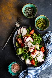 Plate of healthy vegetable salad on rustic background with space for text