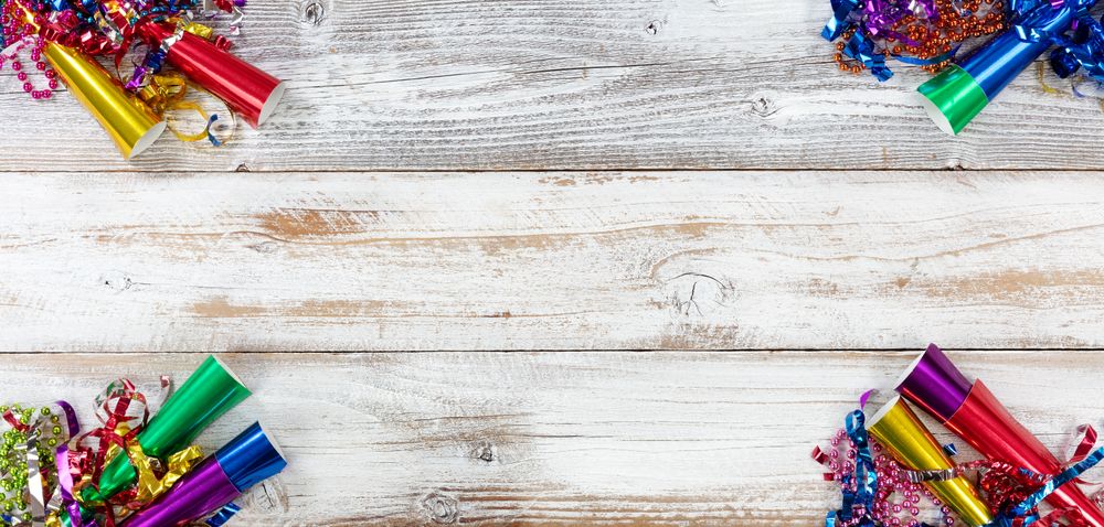 Happy New Year Celebration with party objects on each corner of rustic wooden boards