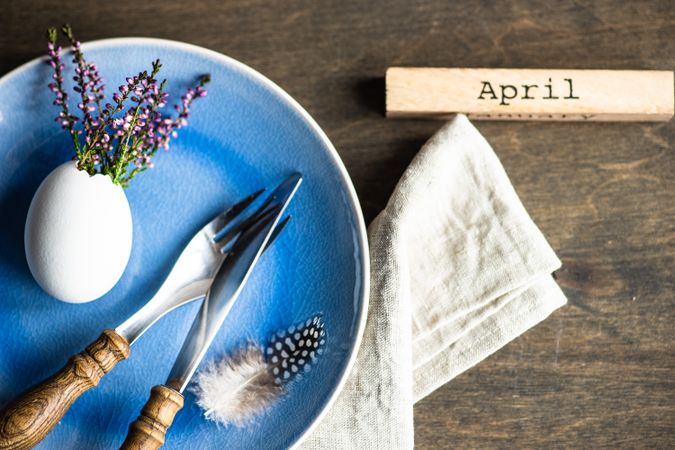 Top view of heather in decorative egg on blue plate for Easter dinner