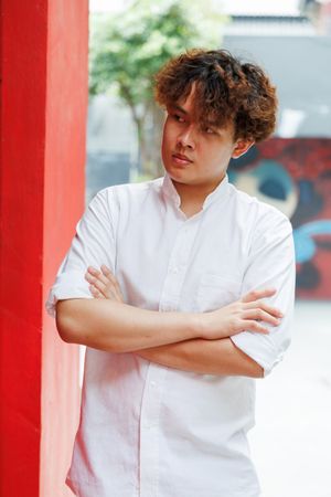 Portrait of Asian man in button up shirt standing in arms crossed