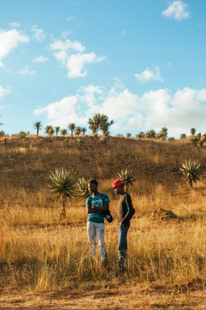 Two men standing in a field in Africa in the sunshine