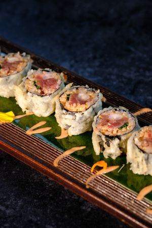 Delicious fried sushi with cream on tray