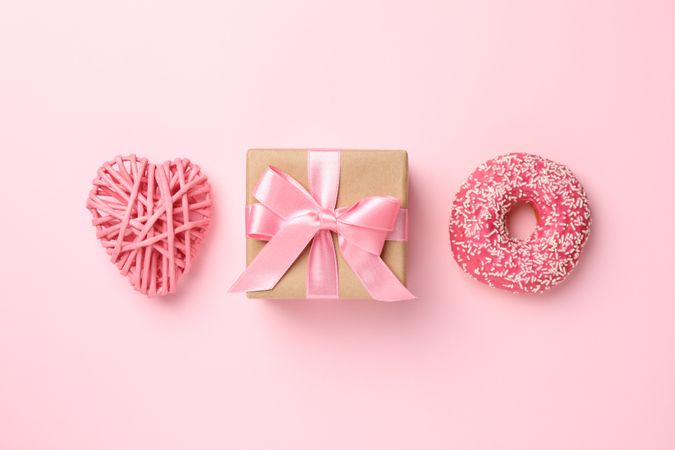 Gift box, donut and heart on pink background, space for text