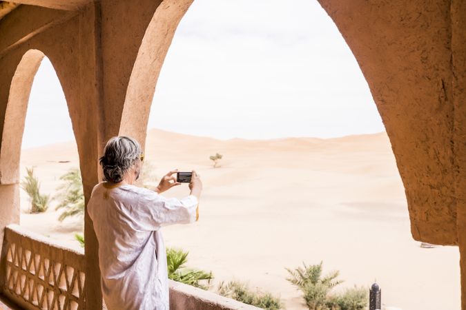 Man taking photo of desert from balcony