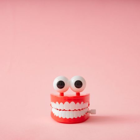 Wind up teeth chatter toy with large eyes on pink backdrop