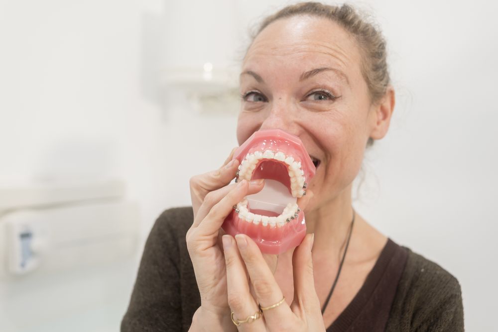 Funny woman playing with jaws in dentist clinic