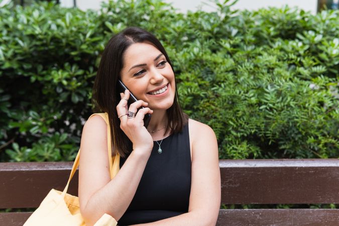 Smiling woman talking on smartphone in city