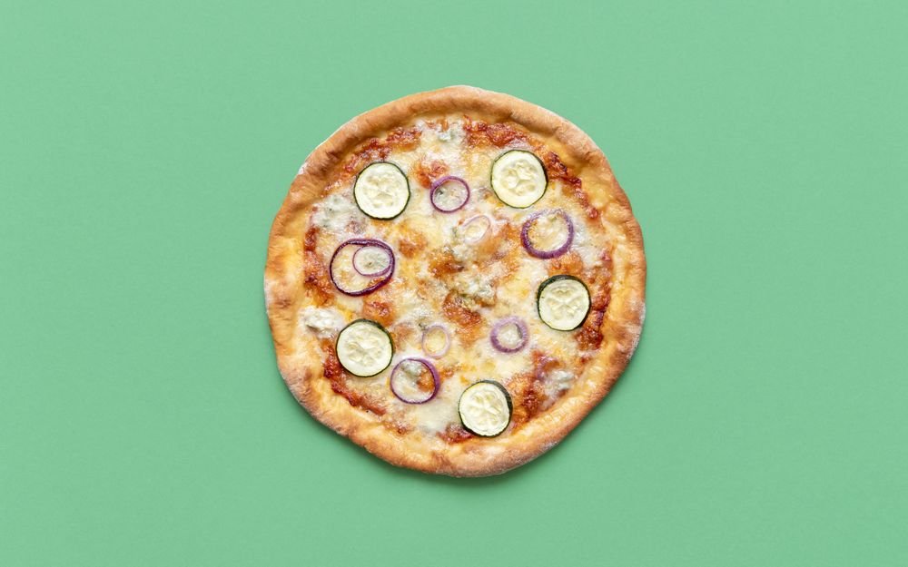 Homemade vegetarian pizza isolated on a green background