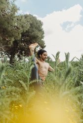 Man training yoga on meadow