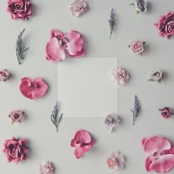 Pink and violet flowers on marble background with paper card