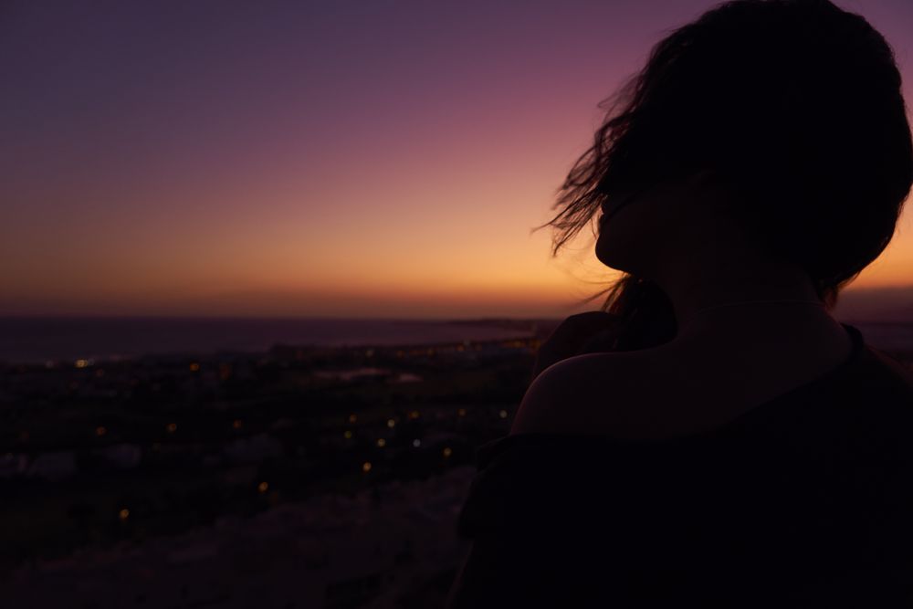 Silhouette of female enjoying picturesque sunset