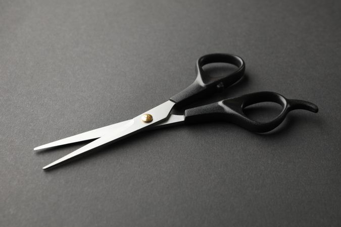hairdresser scissors on dark background, space for text