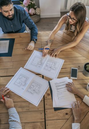 Office workers meeting looking at blueprints