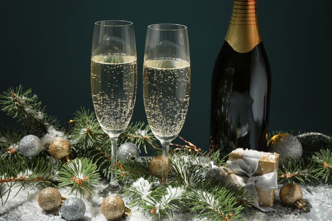 Champagne glasses and bottle on decorated background, close up