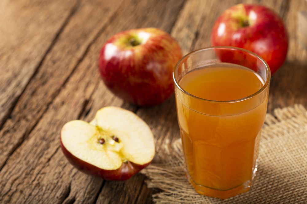 Apple juice and red apples on the table.