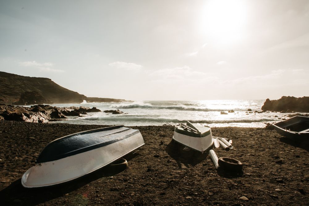 Boats on stony shore near sea