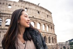 Cheerful Asian traveler outside famous landmark