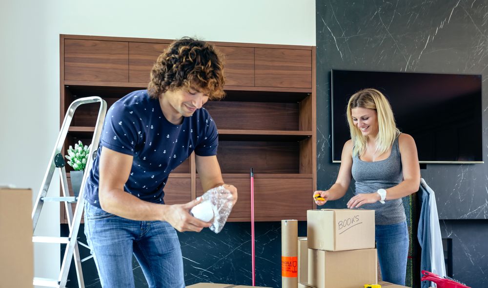 Couple unpacking moving boxes
